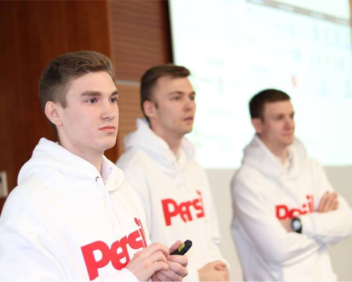Trei angajați Henkel purtând un pulover Persil și ținând o prezentare