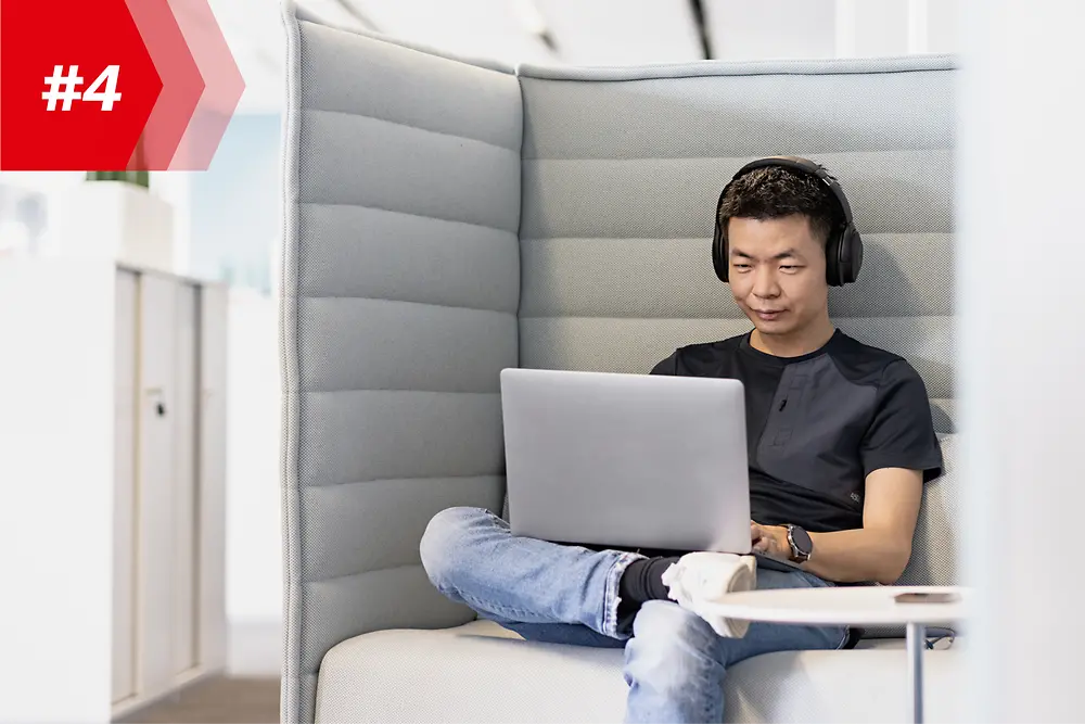 Angajat Henkel Hao, șeful fabricii de aplicații mobile, cu căști și laptopul său