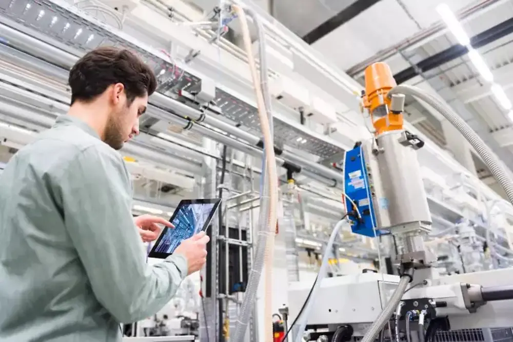 Muncitori care operează utilaje în interiorul unei fabrici industriale.